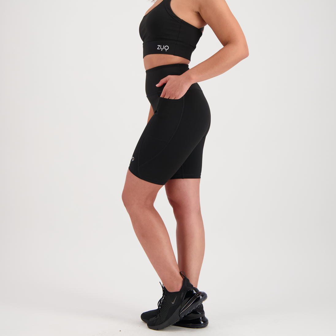 Side view, model in mid-length shorts in black
